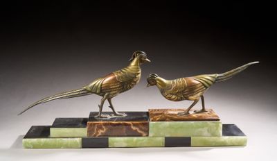 pair of bronze pheasants on marble base on black background