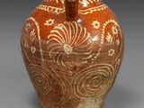 une image représentant un vase marron orné de motifs blancs