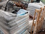 a large pile of boxes and other items in a greenhouse