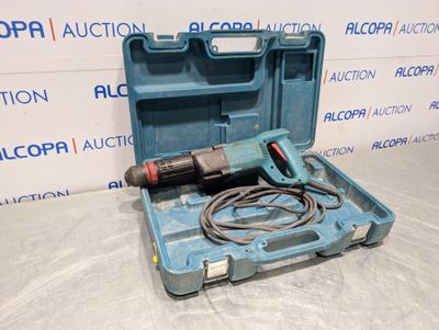 une boîte à outils bleue contenant une perceuse, posée sur une table