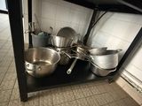 de nombreuses casseroles et poêles sur l'étagère de la cuisine