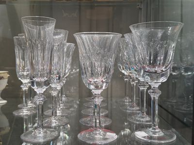 several empty wine glasses on a glass table in a glass case