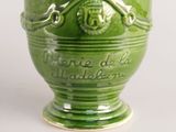 a green vase with a skull and crossbones on it
