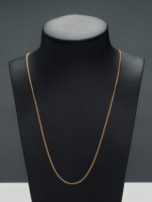 a gold chain necklace on a mannequin neck