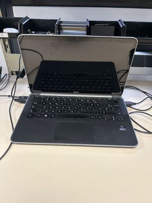 un ordinateur portable posé sur un bureau à côté d'un moniteur