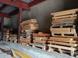 several stacks of wooden pallets are stacked up in a warehouse