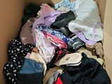 a cardboard box filled with clothes and a pair of shoes