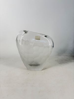 a clear glass vase with a gold label on it