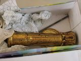a box with a gold object in it on the floor