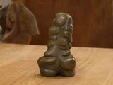 une statue de femme tenant un enfant sur une table