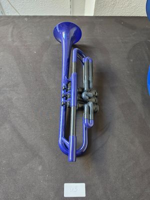 a blue trumpet sitting on a table next to a blue ball