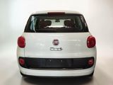 the back end of a small white car with a red tail light