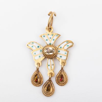 une image représentant un pendentif en or orné d'une croix et de deux larmes