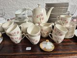 a lot of coffee cups and saucers on a table