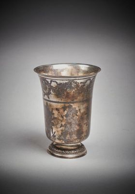 une vieille coupe en argent munie d'une anse, sur fond blanc