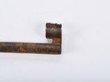 an old rusted key on a white surface