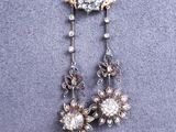 a close up of a necklace with a flower design on it