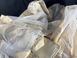 a pile of white cloth on a black surface