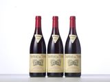 three bottles of wine are lined up on a table