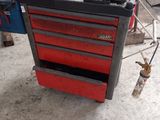 une boîte à outils rouge sur laquelle sont posés des outils, dans un garage