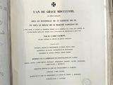 un livre ouvert sur une table, sur lequel est collée une étiquette