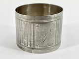 une tasse en argent posée sur une surface blanche