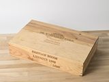 une caisse en bois sur laquelle est collée une étiquette, posée sur un plancher en bois
