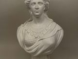 a white marble bust of a woman with curly hair