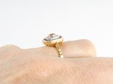 a person ' s hand holding a ring with a diamond on it