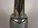 a silver vase sitting on a table with a white background