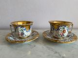 two cups and saucers sitting on a table