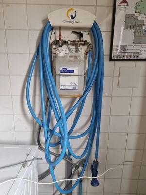 un tuyau bleu raccordé à des toilettes blanches dans une salle de bains