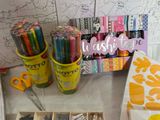 many pens and markers in a box on a table