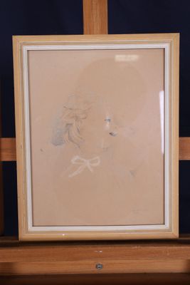 dessin représentant le visage d'une femme dans un cadre posé sur une étagère
