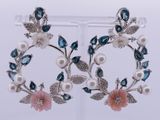 une paire de boucles d'oreilles bleues et blanches ornées de fleurs et de feuilles