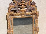 un miroir posé par terre près d'un mur