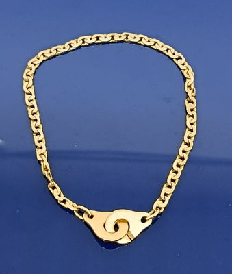 un gros plan d'une chaîne en or avec un cadenas sur un fond bleu