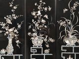 two black panels with white flowers and birds on them