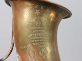 a brass vase with a metal handle on a table