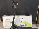 une trottinette électrique posée par terre devant un carton