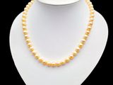 a white necklace with yellow pearls on a mannequin