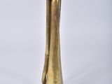 a brass trumpet that is sitting on a white surface