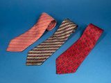 three different colored ties on a blue surface with a blue background