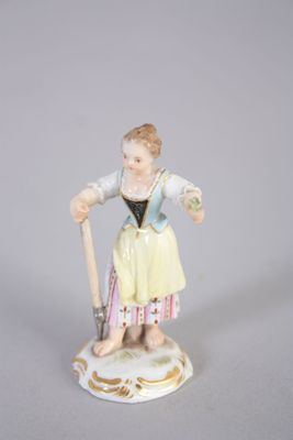 une figurine représentant une femme tenant un bâton