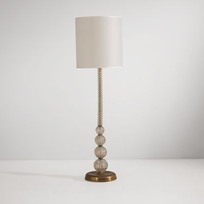 une lampe posée sur une table, avec un abat-jour blanc