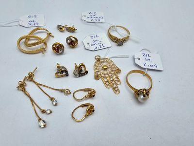 some gold rings and other jewelry are on a white surface