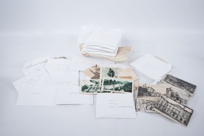 une pile de vieilles photos et de cartes postales posée sur une table