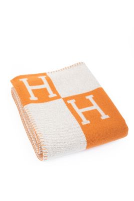 an orange and white blanket with the letter h on it