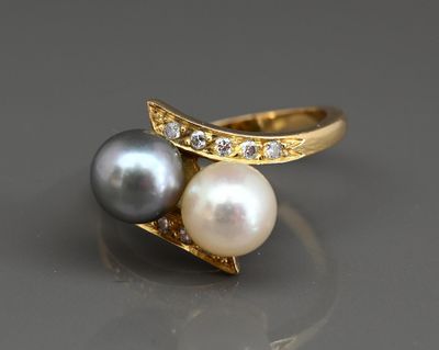 un gros plan d'une bague en perle et diamant posée sur une table