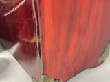 a red vase that is sitting on a white table
